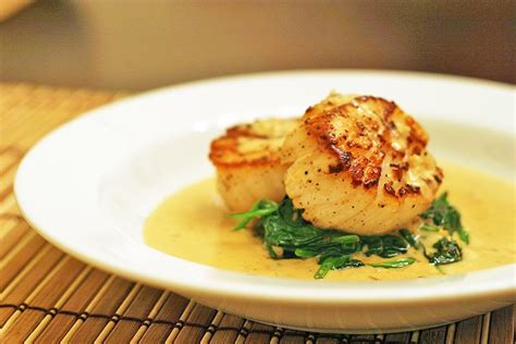seared-scallops-on-spinach-with-apple-brandy-cream image
